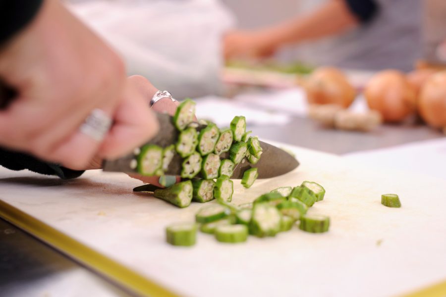 Photograph of Hands chopping okra