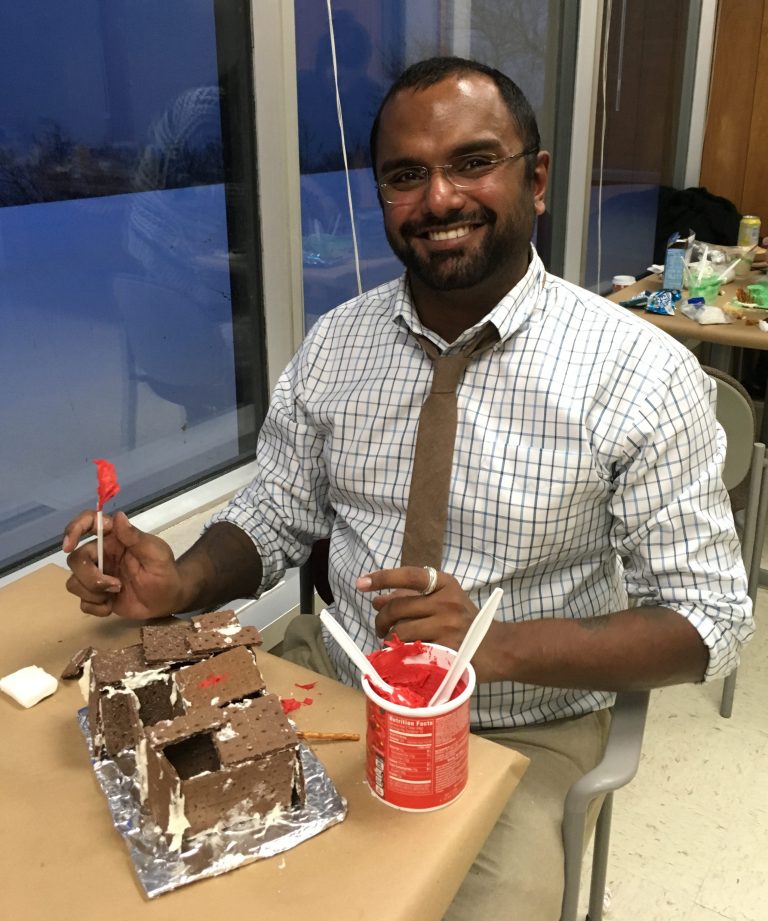 Photograph of Akshay Sarathi building a gingerbread house