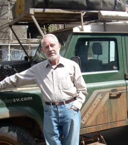 Photograph of Professor Herbert Lewis standing by truck in the field.